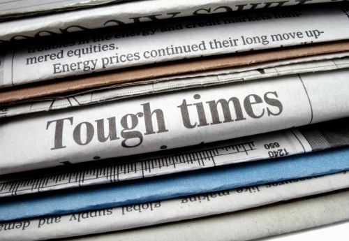 A picture of newspapers highlighting the words "tough times."